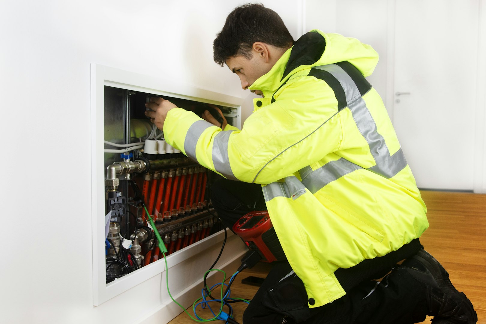 elektriker i gul jacka som jobbar